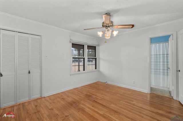 unfurnished bedroom with baseboards, ornamental molding, a closet, and light wood-style floors