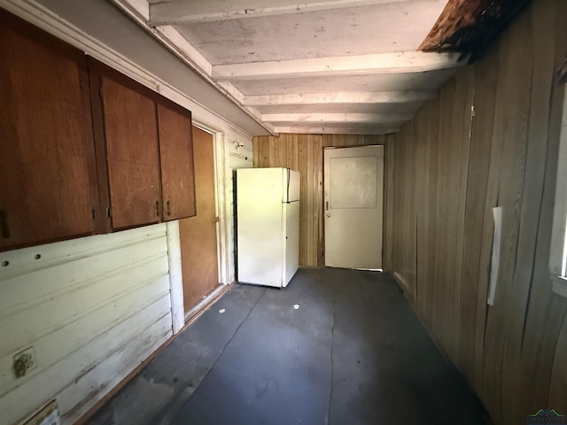 704 Sunset Dr, Marshall, TX 75672 - interior space featuring freestanding refrigerator and wooden walls