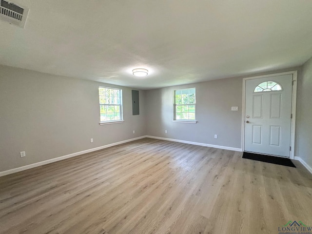 foyer entrance with a healthy amount of sunlight, electric panel, and light hardwood / wood-style floors