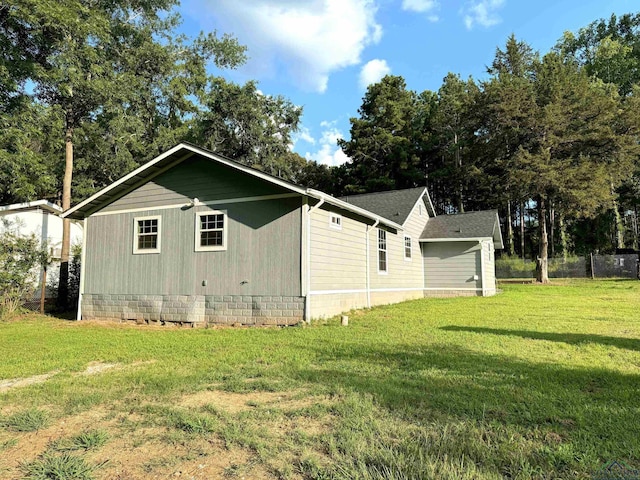 view of side of home with a yard