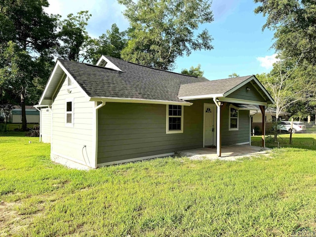 rear view of property with a patio and a lawn