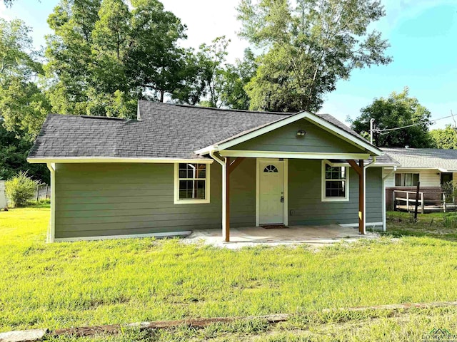 ranch-style home with a front lawn and a patio