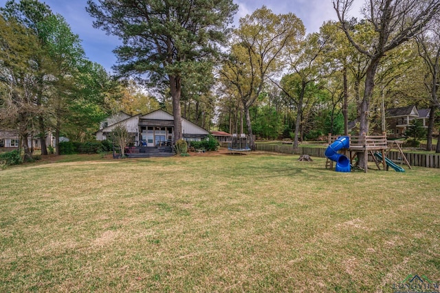 view of yard with a playground and a trampoline