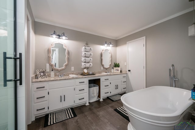 bathroom with hardwood / wood-style floors, vanity, crown molding, and a tub