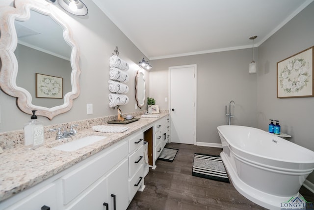 bathroom with wood-type flooring, vanity, ornamental molding, and a tub