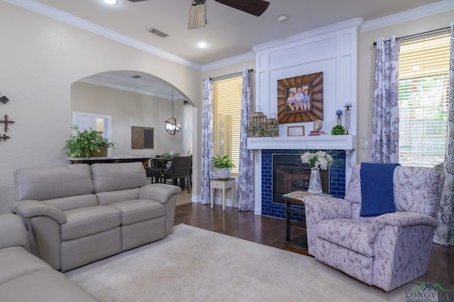 905 Woodridge Cir, Longview, TX 75601 - living area with wood finished floors, arched walkways, ceiling fan, a tile fireplace, and ornamental molding