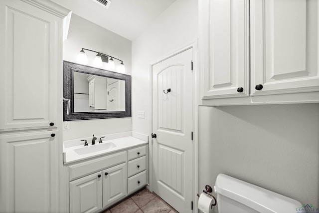 bathroom with tile patterned flooring, vanity, and toilet