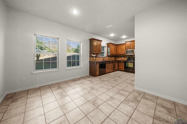 kitchen featuring light tile patterned floors, backsplash, and black appliances