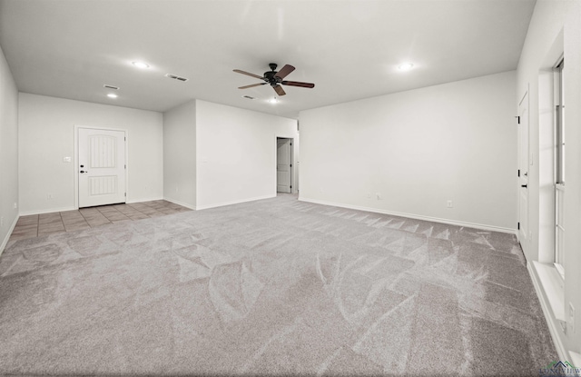 spare room featuring light carpet and ceiling fan