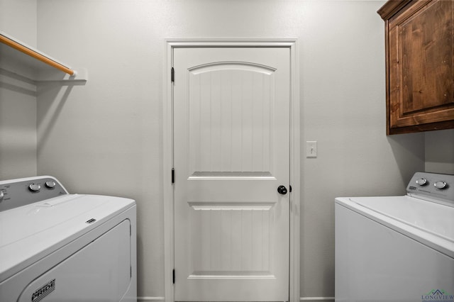 washroom with washer and clothes dryer and cabinets