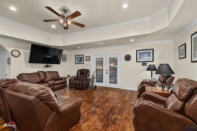 living room featuring wood-type flooring, ornamental molding, ceiling fan, a raised ceiling, and french doors