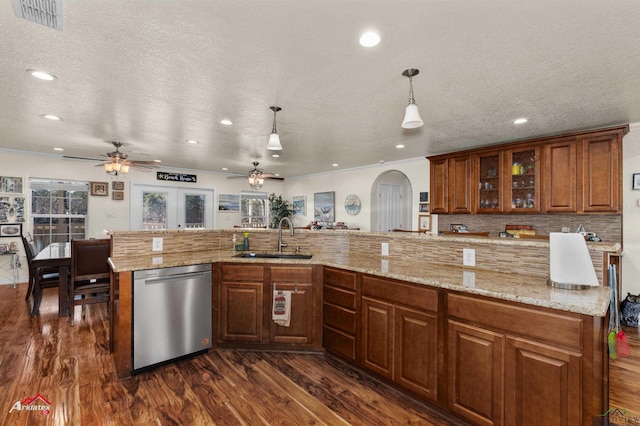 kitchen with tasteful backsplash, dishwasher, sink, hanging light fixtures, and a spacious island