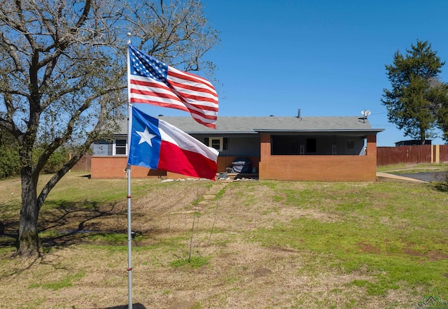 back of property with a yard and fence