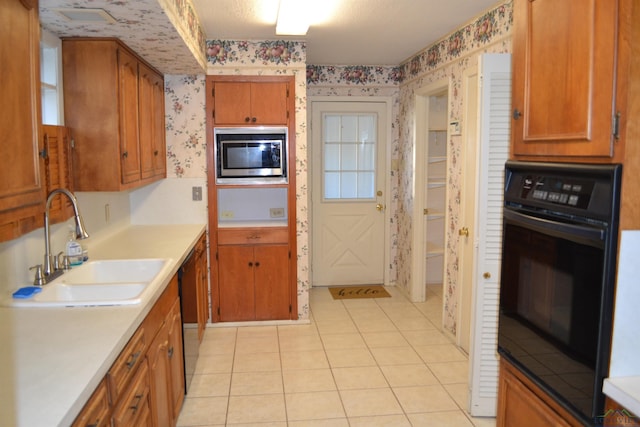 kitchen with light tile patterned floors, sink, and black appliances