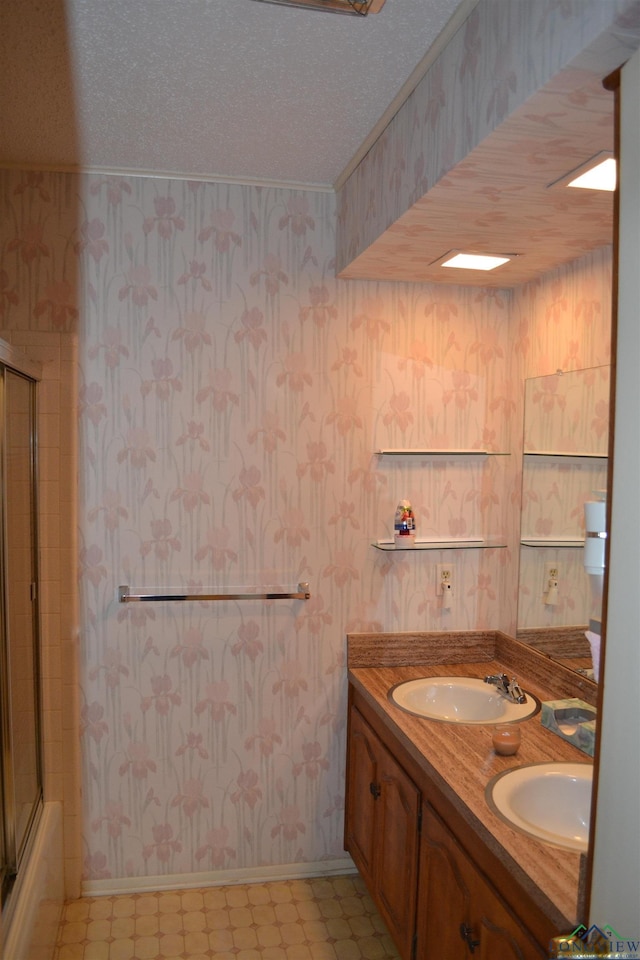 bathroom with vanity, a textured ceiling, and bath / shower combo with glass door