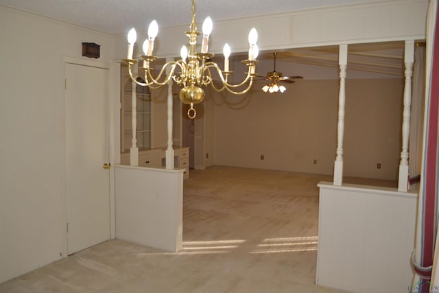 unfurnished dining area featuring ornamental molding, ceiling fan with notable chandelier, light colored carpet, and a textured ceiling