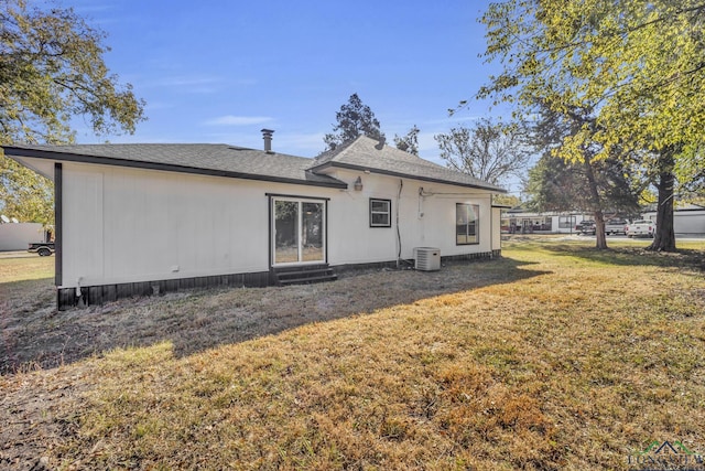 back of property featuring a yard and central air condition unit