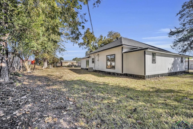 view of property exterior with central air condition unit and a lawn