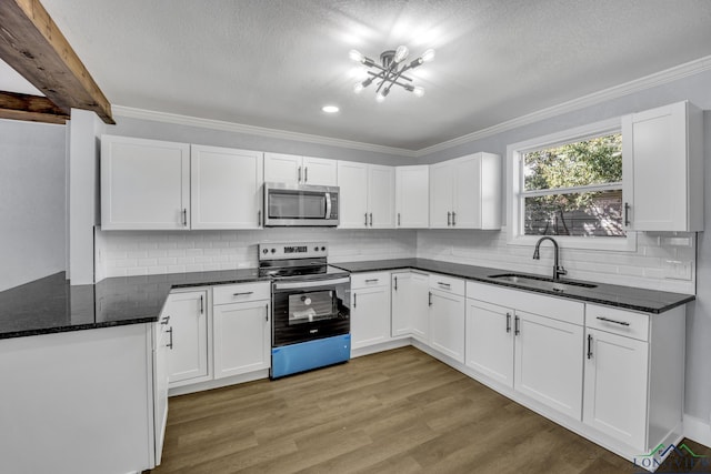 kitchen featuring white cabinets, sink, dark stone countertops, ornamental molding, and stainless steel appliances