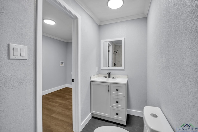 bathroom with toilet, vanity, hardwood / wood-style floors, and ornamental molding