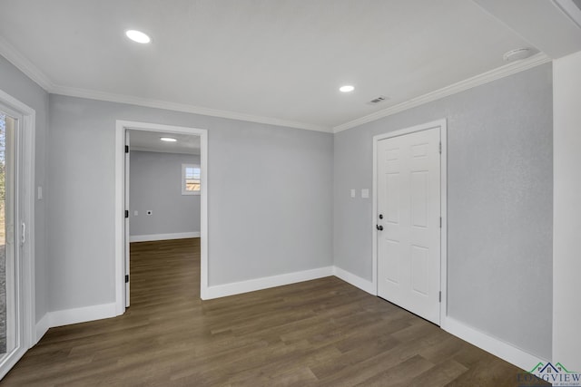 empty room featuring crown molding and dark hardwood / wood-style flooring