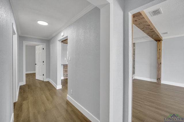 corridor with hardwood / wood-style flooring and ornamental molding