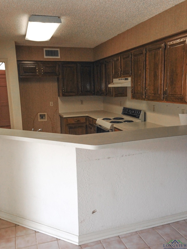 1204-1206 Brandywine, Longview, TX 75601 - kitchen with electric stove, under cabinet range hood, light countertops, dark brown cabinets, and light tile patterned floors