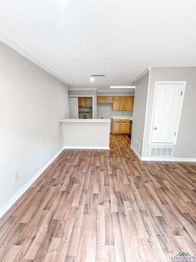 1204-1206 Brandywine, Longview, TX 75601 - unfurnished living room featuring wood finished floors, a textured ceiling, and ornamental molding