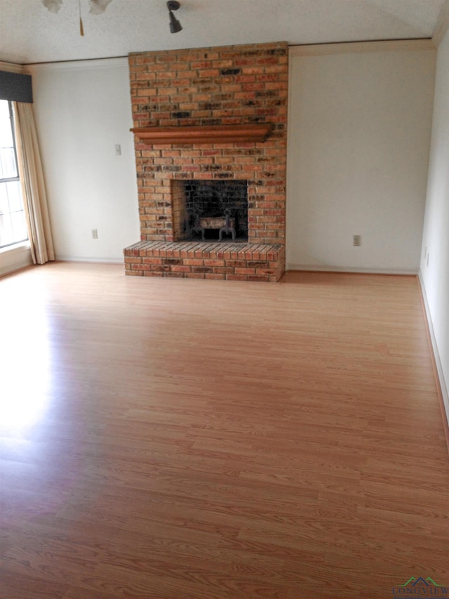 1204-1206 Brandywine, Longview, TX 75601 - unfurnished living room featuring wood finished floors, ceiling fan, ornamental molding, and a fireplace