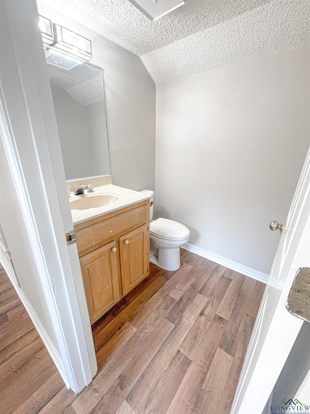 1204-1206 Brandywine, Longview, TX 75601 - half bath featuring a textured ceiling, vanity, wood finished floors, and lofted ceiling