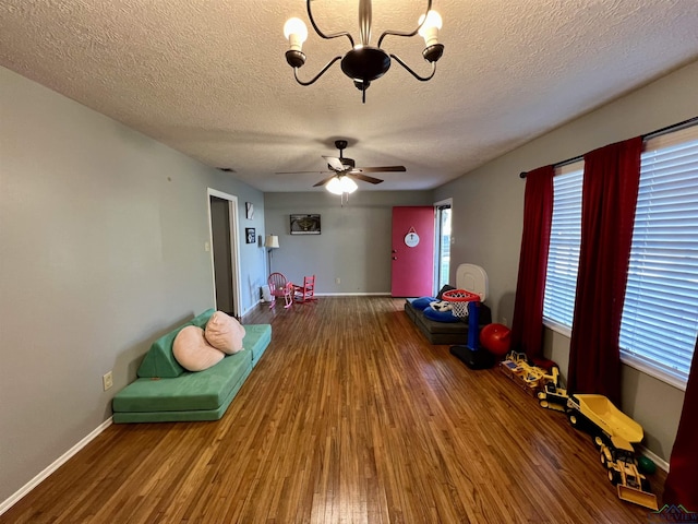 1523 Young St, Henderson, TX 75654 - recreation room featuring baseboards, a textured ceiling, wood finished floors, and ceiling fan with notable chandelier