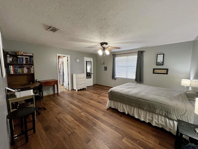 1523 Young St, Henderson, TX 75654 - bedroom with dark wood-style floors, visible vents, a textured ceiling, and a ceiling fan