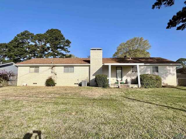 1523 Young St, Henderson, TX 75654 - rear view of house featuring brick siding, a chimney, a yard, and fence