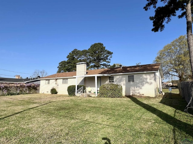 1523 Young St, Henderson, TX 75654 - back of property with a yard, a fenced backyard, a chimney, crawl space, and brick siding