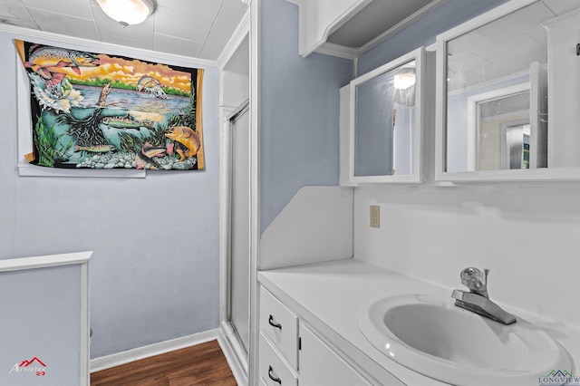 bathroom featuring hardwood / wood-style flooring, vanity, crown molding, and an enclosed shower