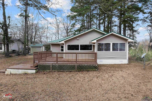 back of property featuring a deck and a shed