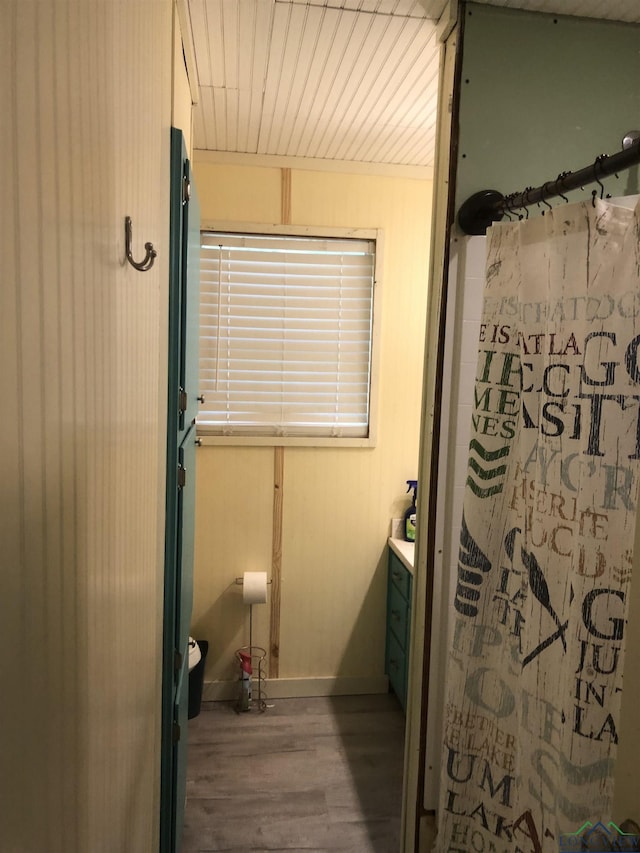 2408 Blairs Landing Rd, Karnack, TX 75661 - full bathroom featuring wood finished floors, curtained shower, baseboards, and vanity