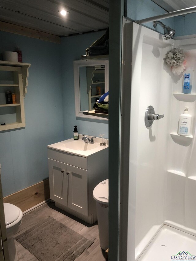 2408 Blairs Landing Rd, Karnack, TX 75661 - bathroom with toilet, wood finished floors, a shower stall, vanity, and recessed lighting