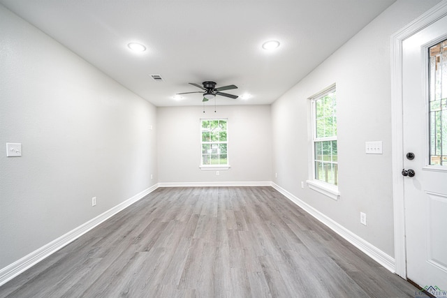 spare room with a wealth of natural light, light hardwood / wood-style flooring, and ceiling fan