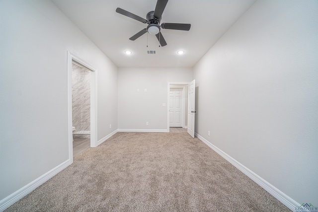 empty room with ceiling fan and light carpet