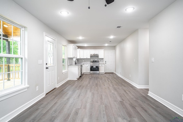 unfurnished living room with ceiling fan, light hardwood / wood-style floors, and sink