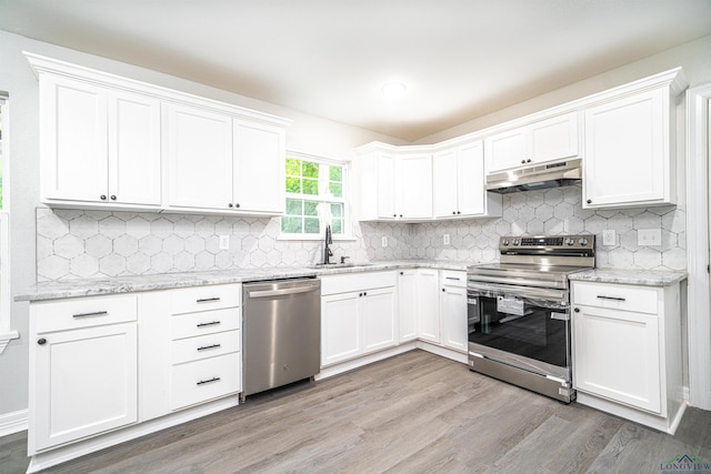 kitchen featuring sink, light hardwood / wood-style flooring, light stone counters, white cabinetry, and stainless steel appliances