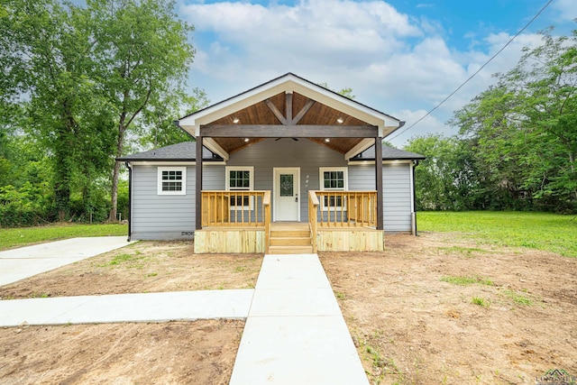 bungalow-style house featuring covered porch and a front yard