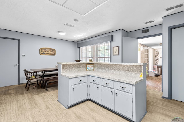 kitchen featuring light countertops, light wood-style flooring, and a textured ceiling