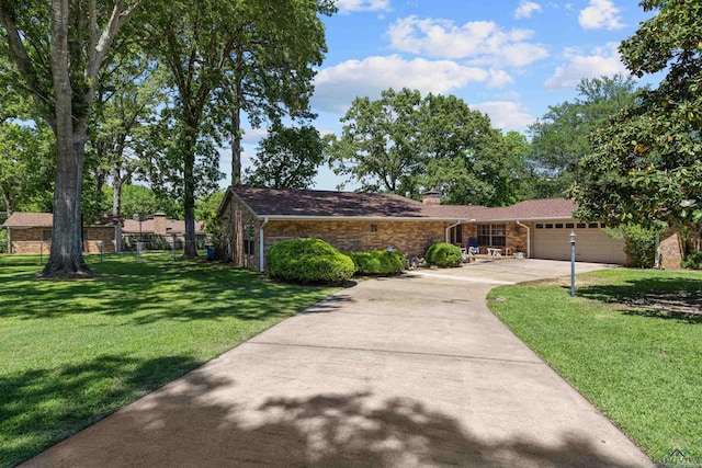 single story home with an attached garage, a chimney, a front yard, brick siding, and concrete driveway
