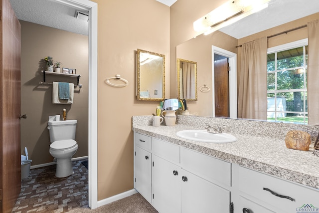 bathroom featuring baseboards, vanity, and toilet
