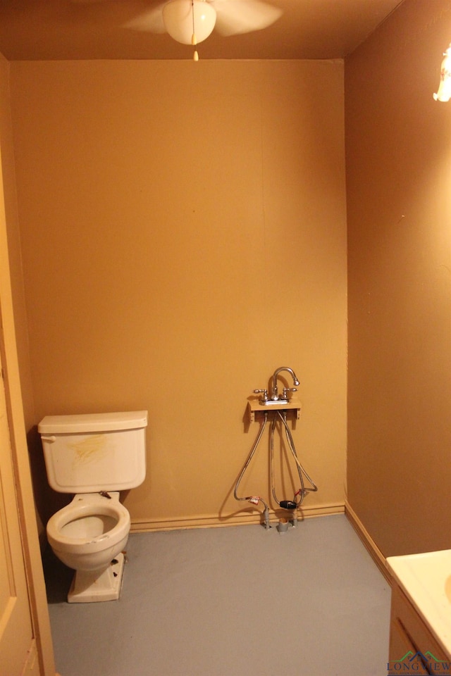 403 N Foster, Linden, TX 75563 - bathroom featuring toilet, vanity, ceiling fan, and baseboards