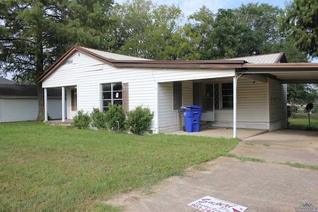 403 N Foster, Linden, TX 75563 - view of side of property featuring concrete driveway, an attached carport, and metal roof