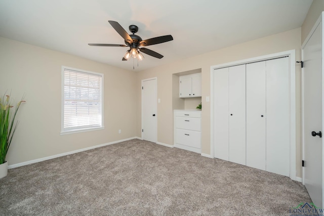 3697 N White Oak Rd, Gladewater, TX 75647 - unfurnished bedroom featuring carpet, baseboards, a closet, and a ceiling fan