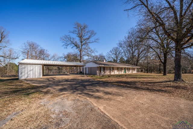 3697 N White Oak Rd, Gladewater, TX 75647 - view of front of house with driveway, a carport, an outdoor structure, metal roof, and a front lawn
